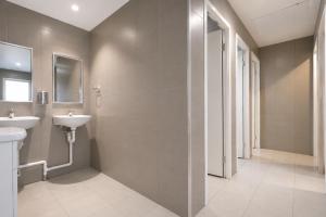 a bathroom with two sinks and a shower at Perth City Backpackers Hostel - note - Valid passport required to check in in Perth +17 photos