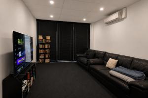 a living room with a couch and a flat screen tv at Perth City Backpackers Hostel - note - Valid passport required to check in in Perth
