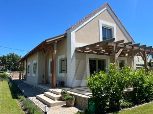 a white house with a porch and a porch at Macskalépcsős Boutique B&B in Dörgicse