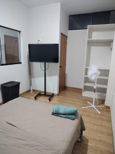 ein Schlafzimmer mit Bett und Flachbildfernseher in der Unterkunft Edificio Las Palmas in Tumbes