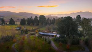 a house in a field with the sunset in the background at Manawa Retreat in Whitecliffs +15 photos