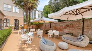a patio with tables and chairs and umbrellas at The Venice Times Hotel, Vignette Collection by IHG in Venice