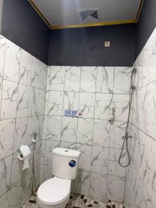 a bathroom with a toilet and a shower at Amita Homestay in Tambolaka Airport
