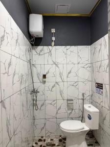 a bathroom with a white toilet in a room at Amita Homestay in Tambolaka Airport