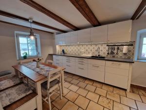 a kitchen with white cabinets and a wooden table at Ferienhaus Altstadtgarten in Beilngries