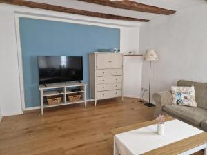 a living room with a television and a couch at Ferienhaus Altstadtgarten in Beilngries