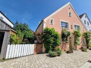 a house with a white fence and flowers at Ferienhaus Altstadtgarten in Beilngries