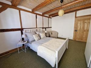 a bedroom with a white bed and a wooden ceiling at Ferienhaus Altstadtgarten in Beilngries
