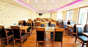a restaurant with tables and chairs in a room at MGallery in Srinagar