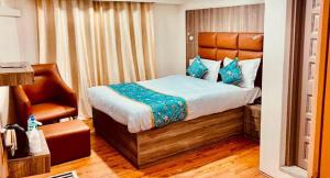 a bedroom with a bed and a chair in it at MGallery in Srinagar +1 photo
