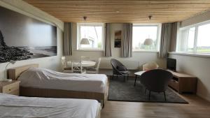 a hotel room with two beds and a table and chairs at Logies De Vlaschaerd in Heule +44 photos