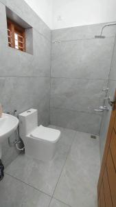 a white bathroom with a toilet and a sink at Hotel Amar Raja in Kurukshetra