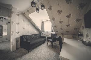 uma sala de estar com um sofá e uma cadeira em Pokoje gościnne Truskawkowa 1a em Zielona Góra