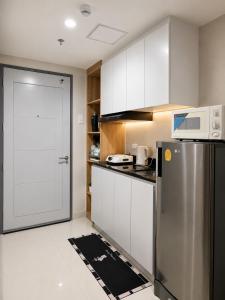 a kitchen with a refrigerator and a microwave at Jtower residences mandaue 27flr in Mandaue City