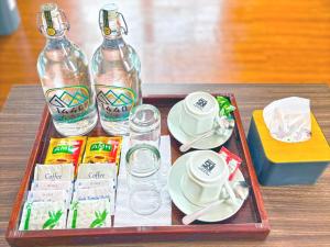 a tray with two bottles of water and cups and drinks at 1440 MDPL Villa & Resort in Wonosobo