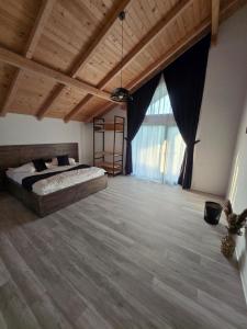 a bedroom with a bed and a large window at Austrian Villa's in Covasna