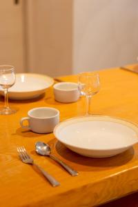 a wooden table with a plate and two wine glasses at furano ski rabi in Furano
