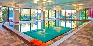 a large swimming pool in a building with windows at Hausboat David in Hrdoňov