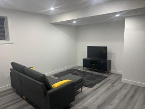 a living room with a couch and a flat screen tv at Peniel Place in Airdrie