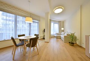 - une salle à manger et un salon avec une table et des chaises dans l'établissement 555 SoleSun, à Druskininkai