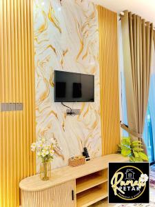 a living room with a tv on a wall at Rumah Petak Melor Muji Concept in Melur