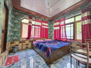 a bedroom with a bed in a room with red curtains at Alamdar guest house in Srinagar