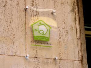 a green sign on the side of a wall at 8 Colonne Apartments in Bologna
