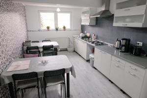 a kitchen with a table and some chairs in it at Pensiunea Sovirag in Praid