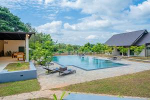 a swimming pool in a yard with a house at Cape Sigiriya in Sigiriya