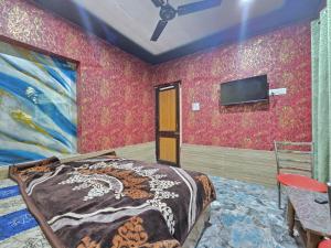 a bedroom with a bed and a tv on a wall at Alamdar guest house in Srinagar