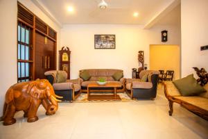 a living room with a couch and a elephant statue at Wenzel Villa in Hikkaduwa