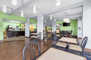 a dining room with tables and chairs and green walls at Quality Inn Walterboro I-95 in Walterboro