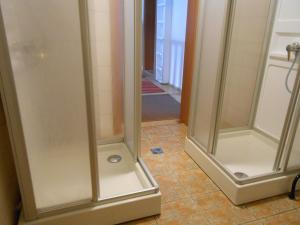 two shower stalls in a bathroom with a tile floor at Ferienhaus Dankl in Hollersbach im Pinzgau +45 photos