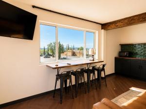 a kitchen with a bar with stools and a window at The Wesley Boutique Hotel Page, AZ in Page