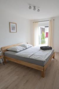 a bed in a white room with a large window at Ferienwohnung Land Leben in Ziertheim
