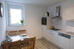 a white kitchen with a table and a dining room at Ferienwohnung Land Leben in Ziertheim