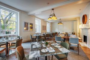 a restaurant with tables and chairs and a fireplace at The Carolina Inn, a Destination by Hyatt Hotel in Chapel Hill