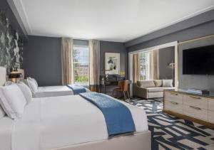 a bedroom with a large bed and a living room at The Carolina Inn, a Destination by Hyatt Hotel in Chapel Hill +65 photos