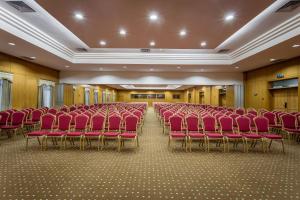 um quarto grande com cadeiras vermelhas num edifício em Hotel Vip Grand Maputo em Maputo