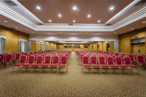 a large room with red chairs in a building at Hotel Vip Grand Maputo in Maputo