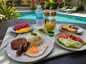a table topped with plates of breakfast food next to a pool at Villa España in San Narciso