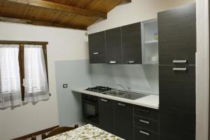 una cucina con armadi neri e lavandino di Camping Ali Baba a Ceriale