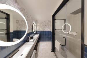 a bathroom with two sinks and two mirrors at Caption by Hyatt Namba Osaka in Osaka +83 photos