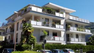 リーヴァ・デル・ガルダにあるSole Riva apartmentの白いアパートメントで、バルコニーに植物が植えられています。