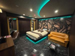 a bedroom with a bed and a desk and a chair at Que キュー -レジャーホテル in Shizuoka