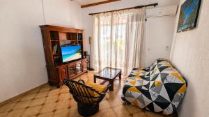 a living room with a couch and a television at La Casa Créole, spa, 3 ch, 2 sdb, centre de la Guadeloupe in Les Abymes