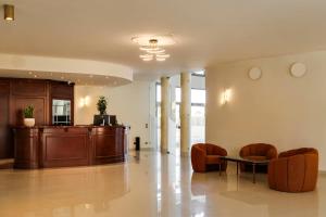 eine Bürolobby mit Schreibtisch, Stühlen und einem Tisch in der Unterkunft HC Hotel Cremona Pilgrim's in Cicognolo + 61 Fotos