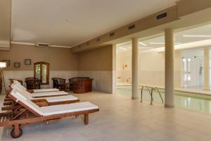 ein Raum mit Pool und einer Reihe von Liegen in der Unterkunft HC Hotel Cremona Pilgrim's in Cicognolo