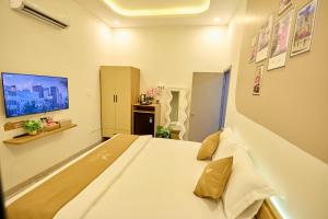 a bedroom with a large bed in a room at Maison Boutique Hotel - Bình An in Phước Lộc Xã