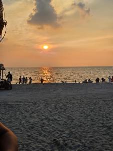 a group of people on the beach at sunset at Villa España in San Narciso +7 photos